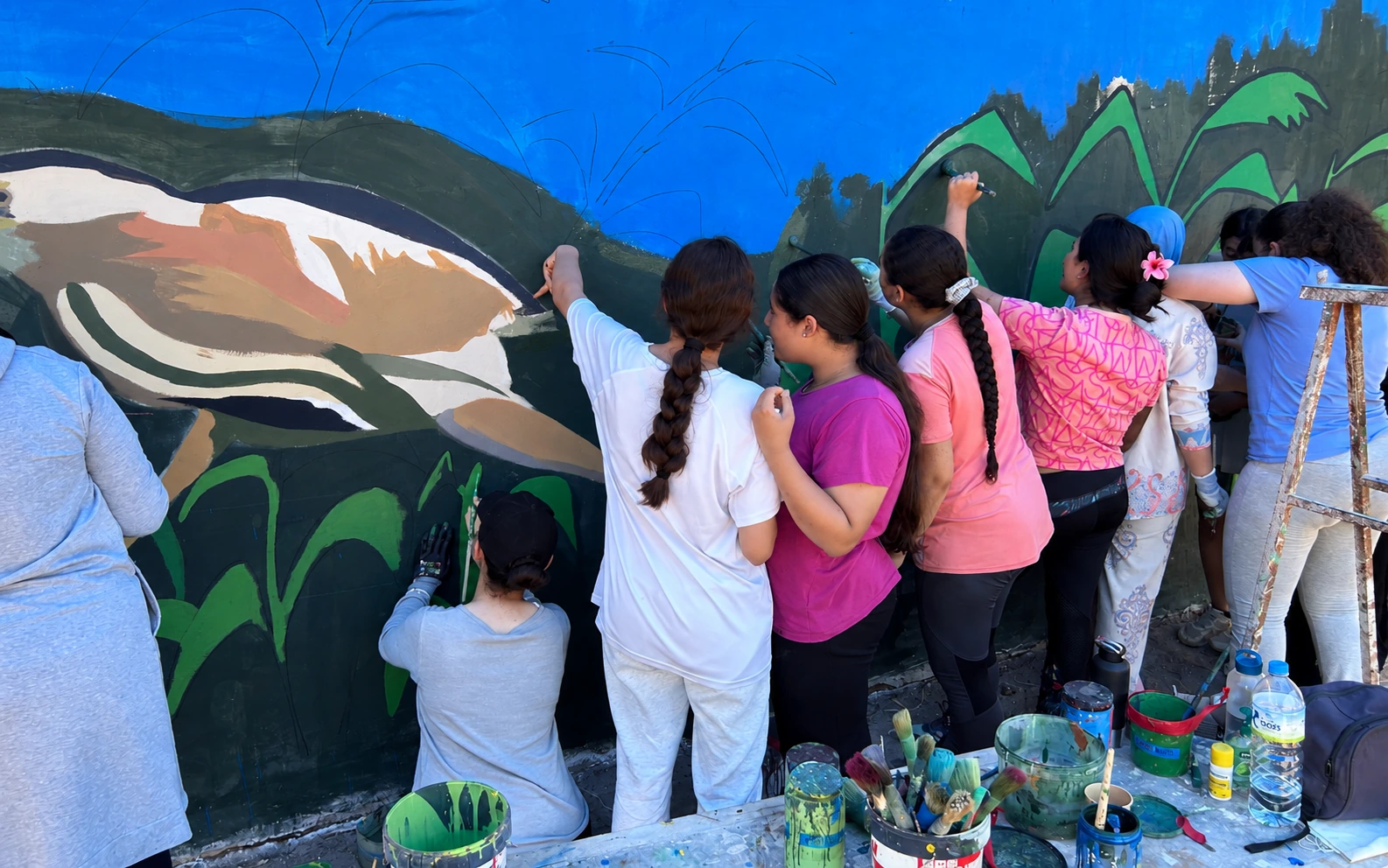 Niñas y niños participando en un mural educativo y medioambiental en Melilla